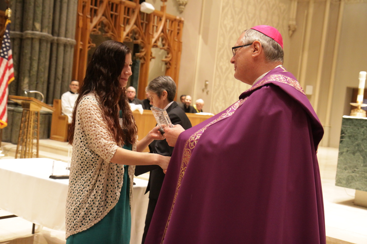 Emily Cuellar, a freshman studying psychology and religious studies at Salve Regina University, receives from Bishop Thomas J. Tobin the St. Timothy Award in recognition of her service inspiring young people to follow their faith at the Rejoice in Hope Youth Center. "Emily is on fire with her faith. She is a dedicated follower and servant of Jesus, giving witness to her faith and her love for God in all she does," her nominator for the award wrote of Emily. Other winners in the category were Daniel Arteaga, Kyle Aubin, Thomas Desmarais, Lauren King, Aaron O?Brien Mackisey, Jordan Robitaille, Kara Tracy, Ashley van Orsouw and David Zuleta.