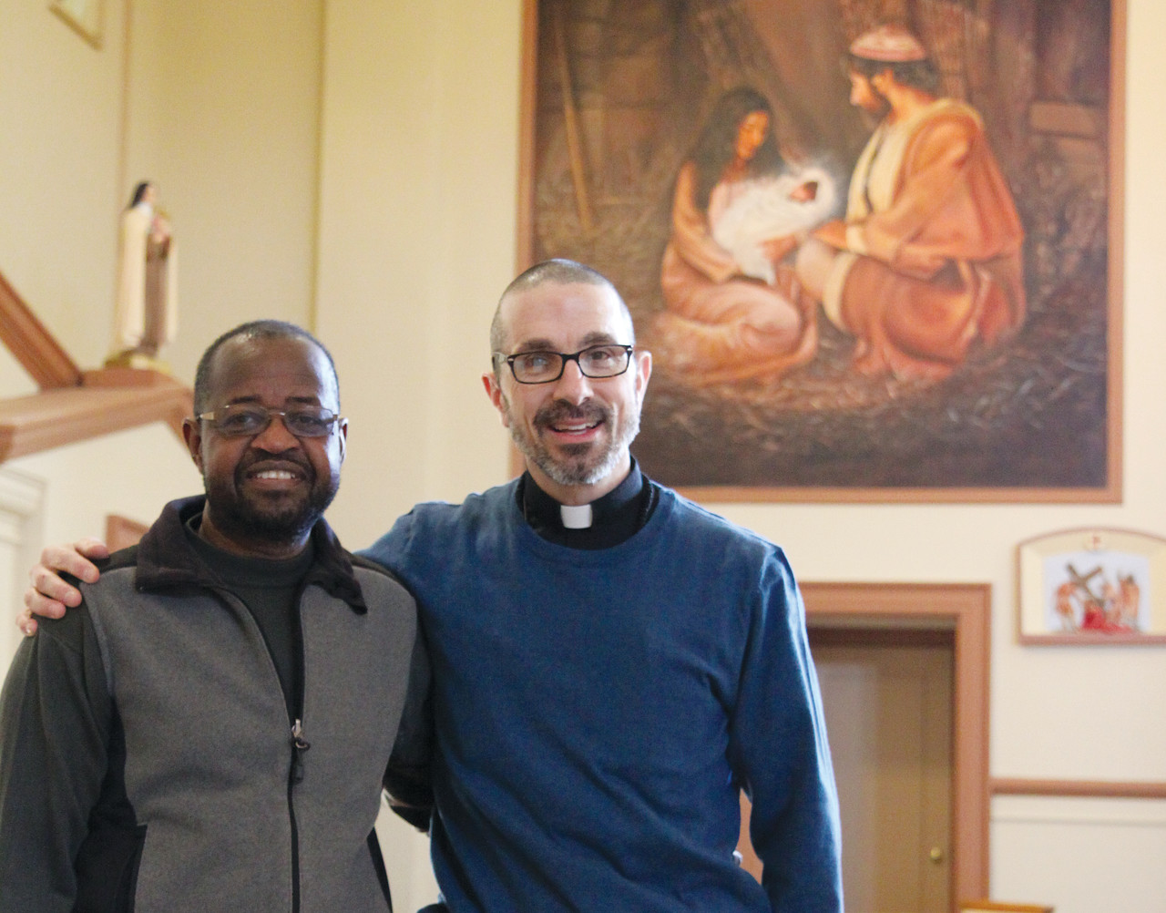 SOLIDARITY: From left to right, artist Munir Deishinni Mohammed and Father James Ruggieri hope their collaboration on the St. Patrick renovations will encourage other interfaith projects in the community. Both men named the nativity scene, pictured behind them, as their favorite painting in the collection.