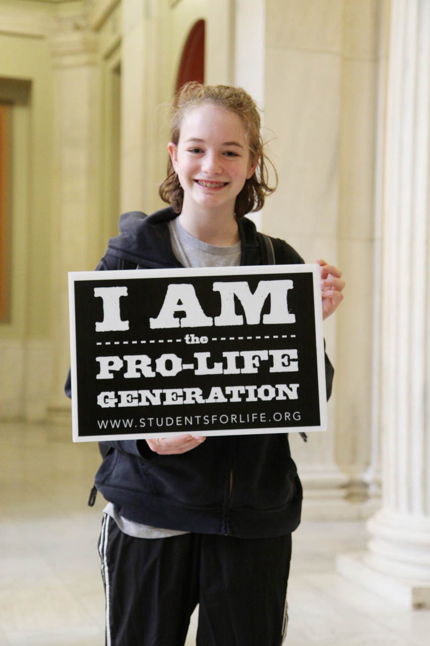 Charlotte McInnis, a parishioner at Holy Apostles Church, Cranston, and eighth-grader at Masters Regional Academy, Smithfield, holds a sign that reads “I Am the Pro-Life Generation.” “I feel like it’s important, especially my generation, to support what I think is right,” she said.