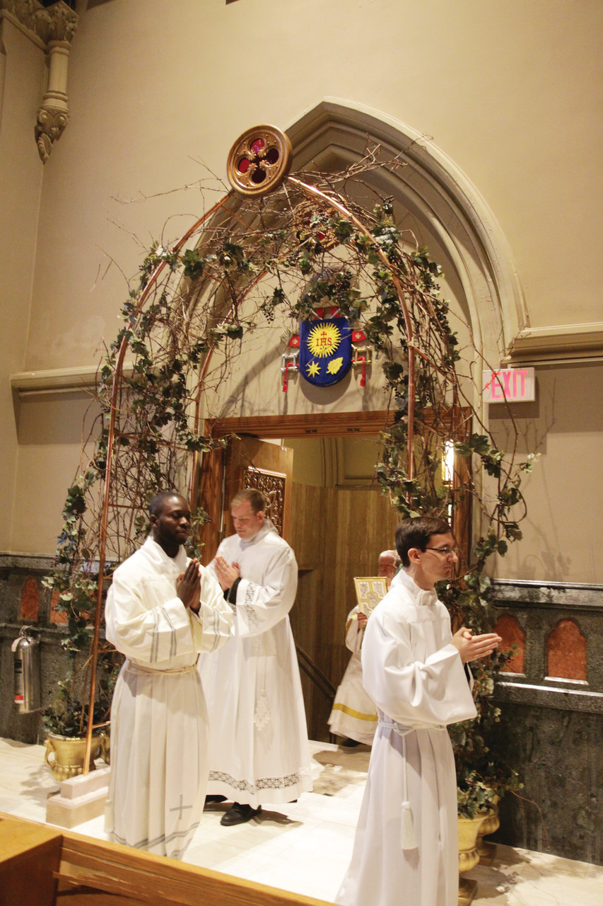 Stephen M. Battey, Jean Joseph Brice and Brian J. Morris walk through the cathedral Holy Door to their ordination as transitional deacons.