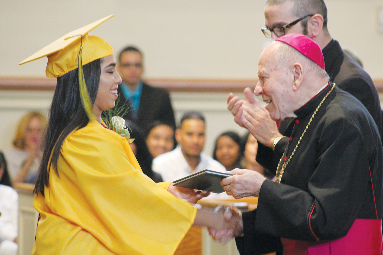 Elibel Fernandez accepts her diploma from Bishop Emeritus Louis E. Gelineau.