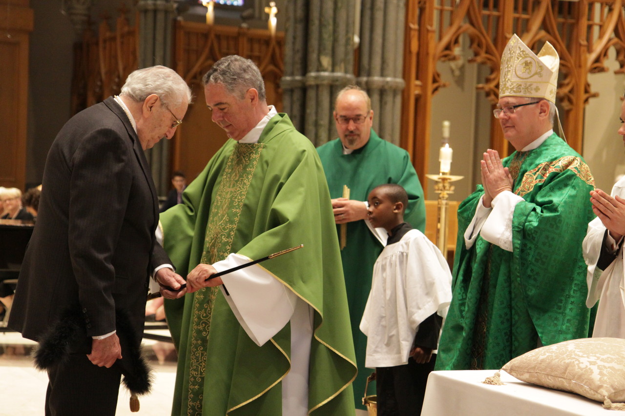 Investiture: The Hon. Thomas J. Caldarone Jr., receives the sword, one of the symbols of those serving as a knight of St. Gregory the Great, from Assistant Moderator of the Curia Father Jonathan DeFelice, O.S.B., as Bishop Thomas J. Tobin, who nominated Caldarone for the Vatican honor, looks on.