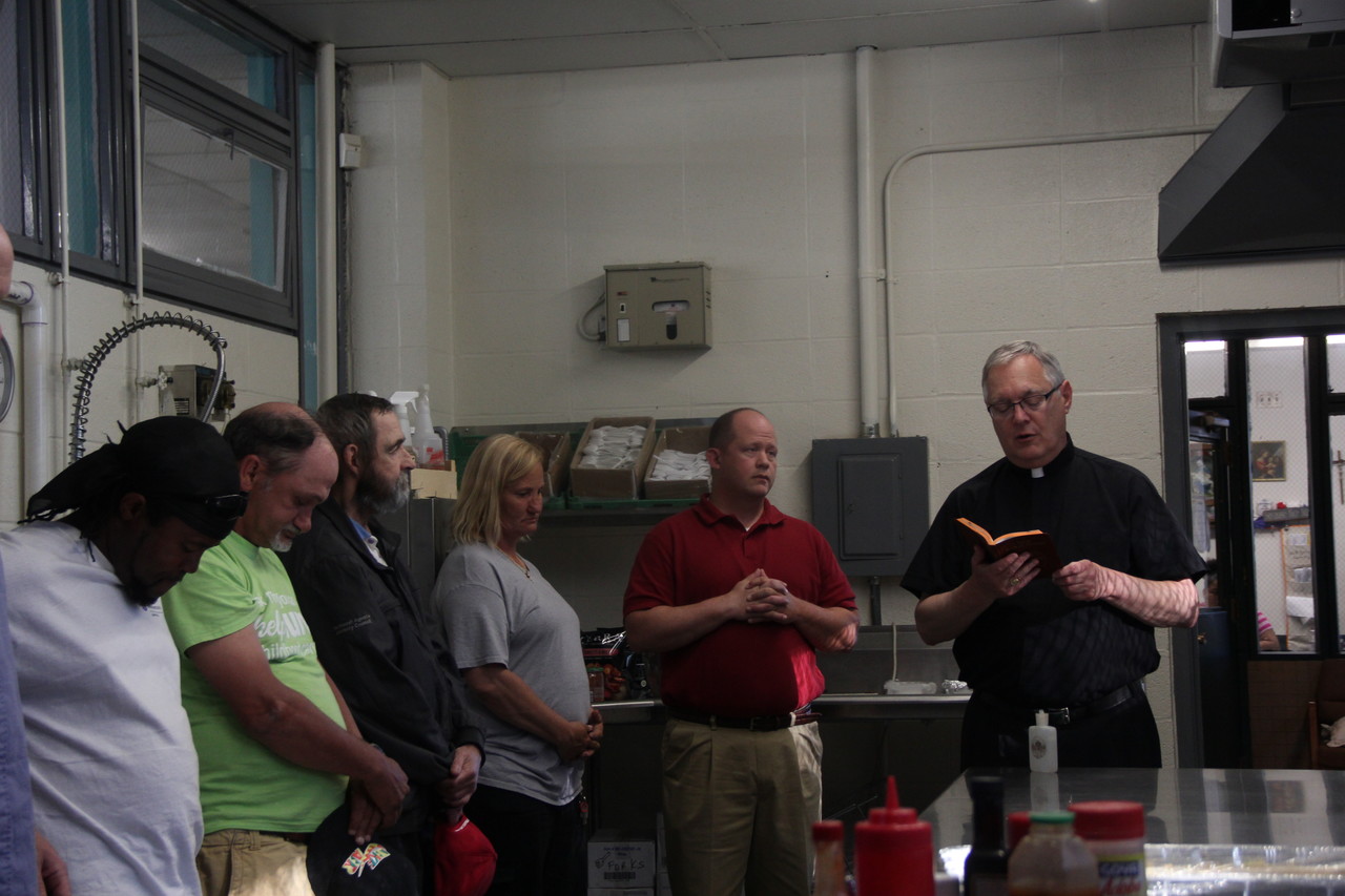 GREAT BLESSINGS: Bishop Thomas J. Tobin offers a prayer and blessings over the new Emmanuel House kitchen with staff and guests.