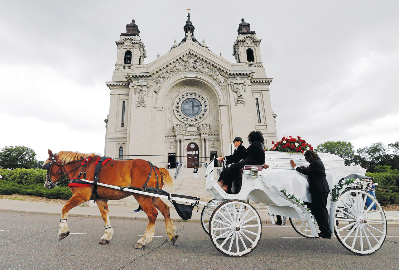A horse-drawn carriage carries the casket of  Philando Castile July 14 as it passes the Cathedral of St. Paul in St. Paul, Minn. Church officials say the mother of 32-year-old man, who was not Catholic, requested the cathedral hold an ecumenical funeral service for her son. Castile was shot and killed by a police officer July 6.