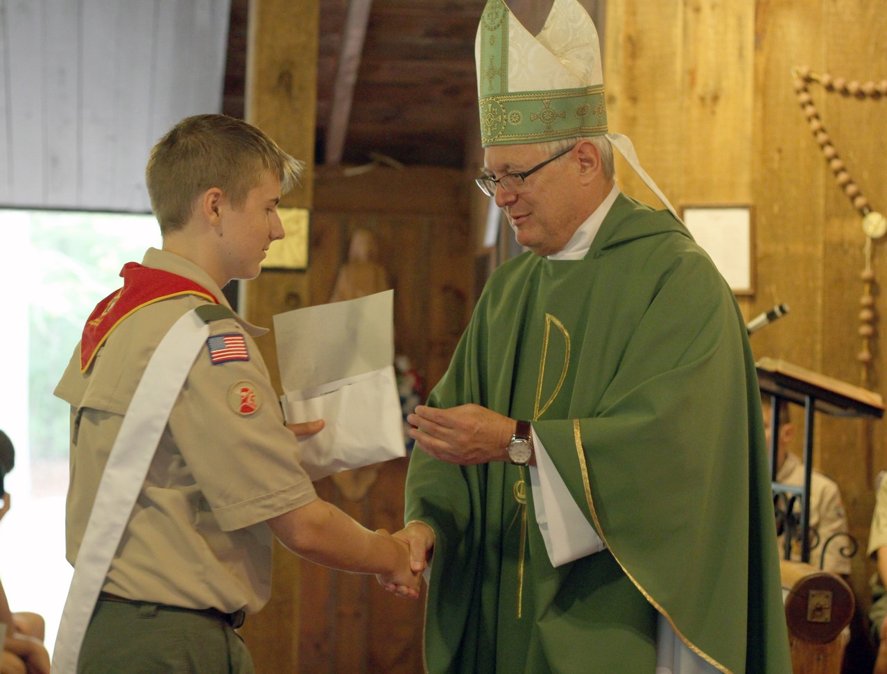 Following Mass, Bishop Tobin awarded Stephen Grivers, 16, of Providence Troop 76, with a Scout award for attending daily Mass each day at his weeklong stay at Yawgoog.