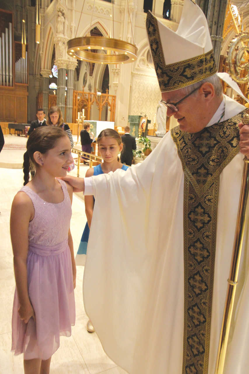 Bishop Thomas J. Tobin greets Sydney Khoury and her family. Bishop Tobin shared that it could be through the intercession of Mother Teresa that Sydney was cured from a devastating illness so quickly following the blessing with the relic, although he is quick to minimize his role in Sydney’s healing process.