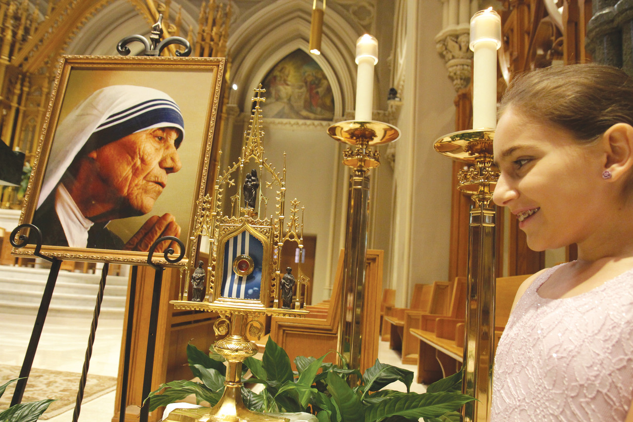 Sydney Khoury admires a relic of Mother Teresa that was used by Bishop Thomas J. Tobin to bless the young girl who was diagnosed with cancer in 2008. Sydney’s family attributes her remarkable recovery to the saints’ intercession.