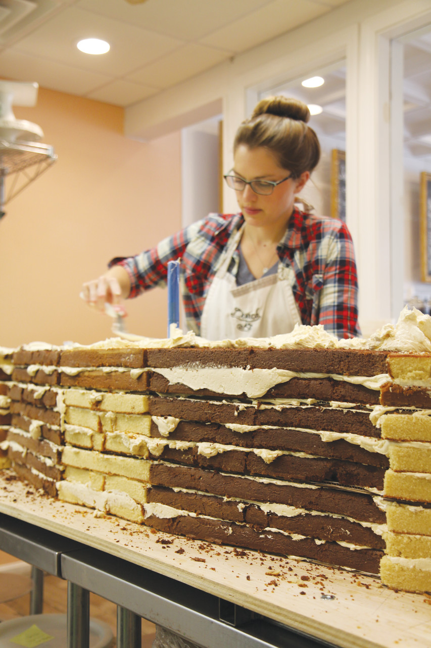 Amanda Oakleaf, co-owner of Oakleaf Cakes, frosts a portion of the Providence College 100th anniversary cake during assembly at the Boston bake shop last Thursday. The cake was created to commemorate the PC Centennial and unveiled at last Saturday’s St. Dominic Weekend celebration.