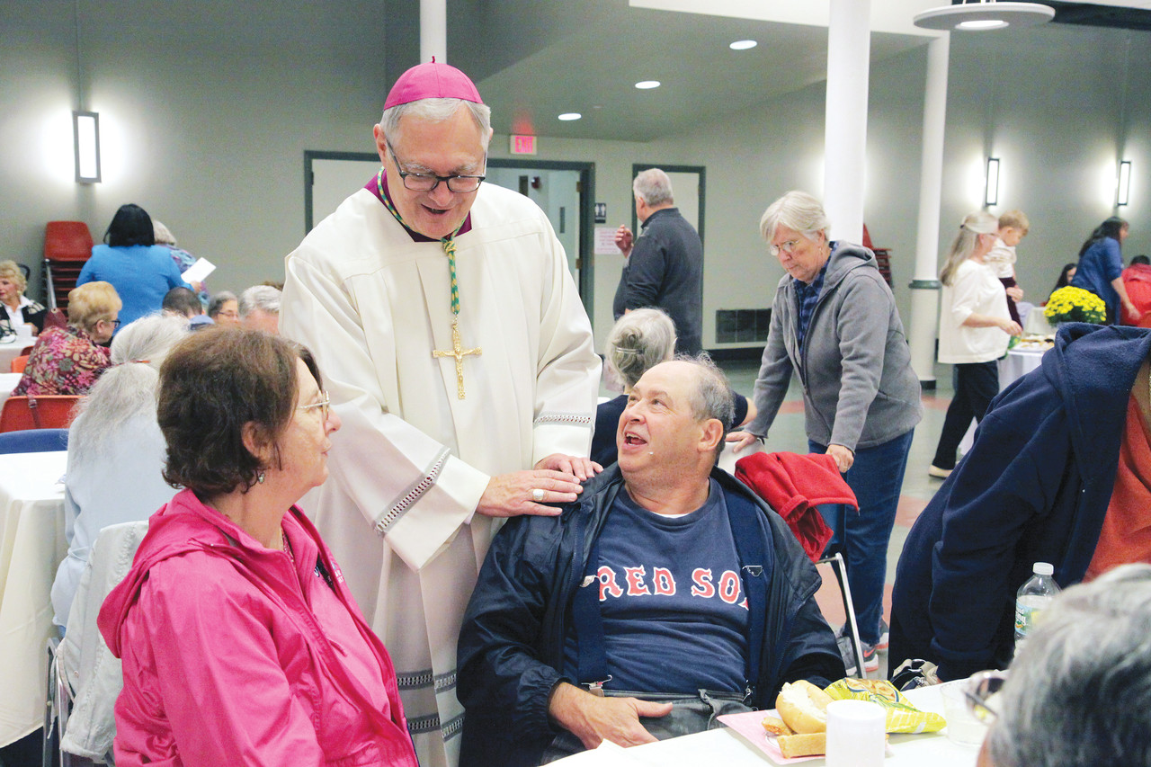 Bishop Thomas J. Tobin greets SPRED participant Ray Ellsworth and his sister, Pat Jankowski, at a reception following the pilgrimage.