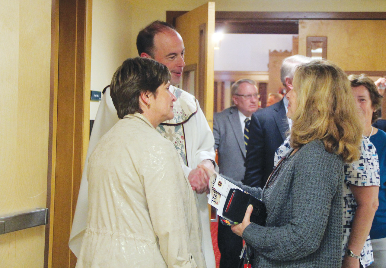 OFFERING SUPPORT and FRIENDSHIP: At left, Patti Cafaro, a registered nurse at Roger Williams Medical Center, introduces Father Timothy Reilly, diocesan Chancellor, to Carol Corcelli. Corcelli’s daughter Isabella recently lost her battle with cancer at the age of 21. Her nurses, Cafaro and Doreen Thomas, invited their friend and beloved patient’s mother to join them in prayer at the annual White Mass. Corcelli shared that Isabella’s nurses inspired her to renew her faith as her daughter underwent treatment for her illness.