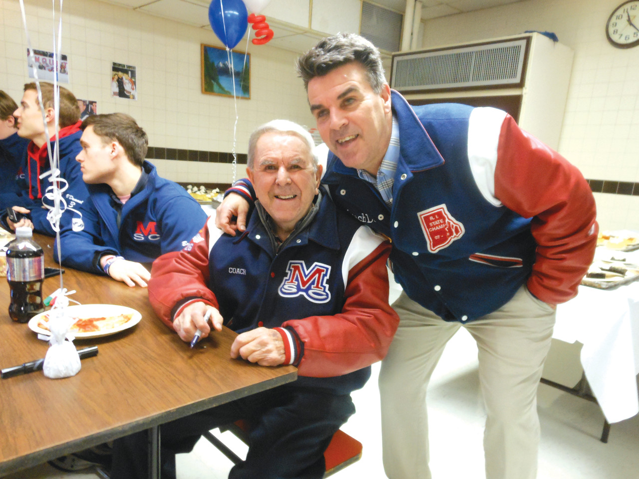 Normand “Bill” Belisle, hockey coach of 42 years at Mount St. Charles Academy, and his son, Dave, smile at an event honoring the older Belisle’s induction into the U.S. Hockey Hall of Fame last fall.