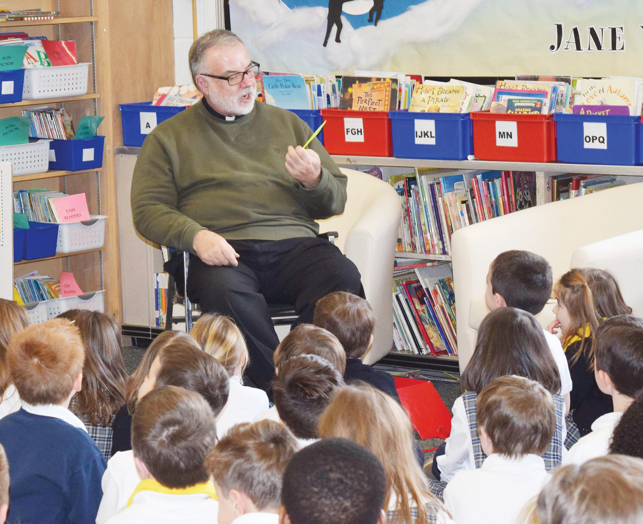 Father Paul Desmarais from St. Mary’s/St. James visits with primary students.