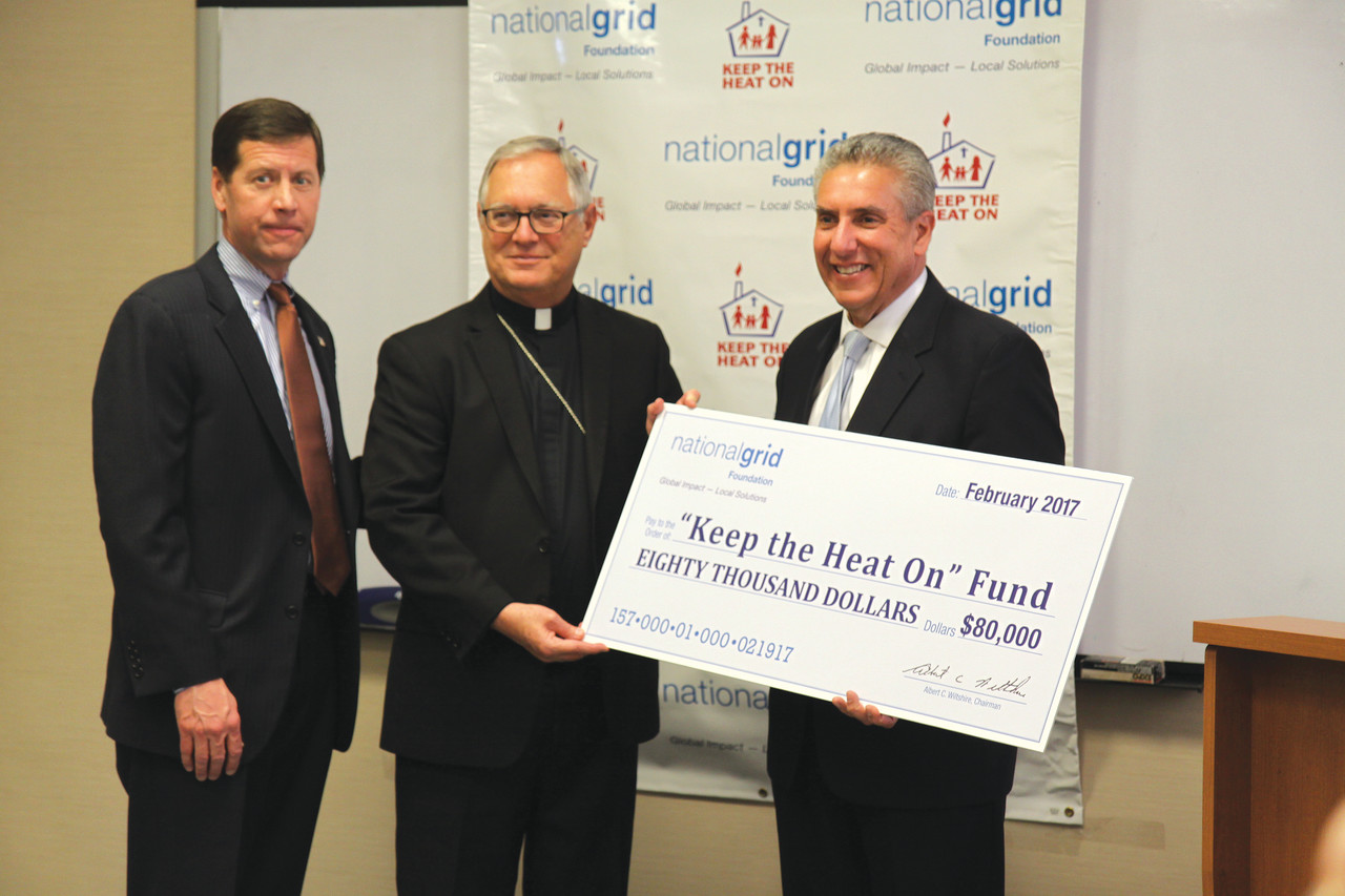 GENEROUS GIFT: National Grid Foundation President Bob Keller (far right) and President and COO of National Grid Rhode Island Tim Horan present a check for $80,000 to Bishop Thomas J. Tobin to support the diocesan “Keep the Heat On” program. “Keep the Heat On” provides emergency heating assistance to Rhode Island families who have exhausted all other means of public and private assistance.