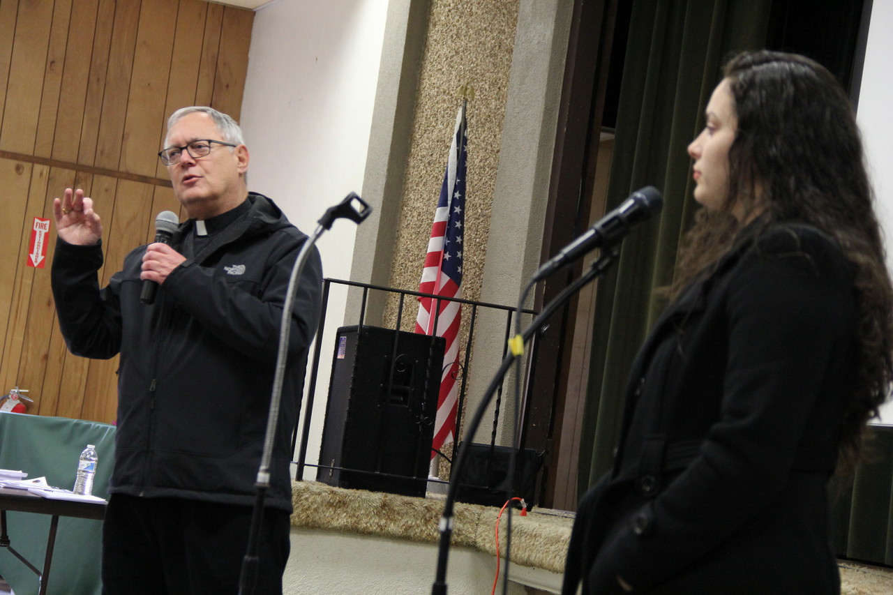 Bishop Thomas J. Tobin, with his message being translated into Spanish by Genesis Flores, speaks to a crowd at Holy Spirit Parish in Central Falls.