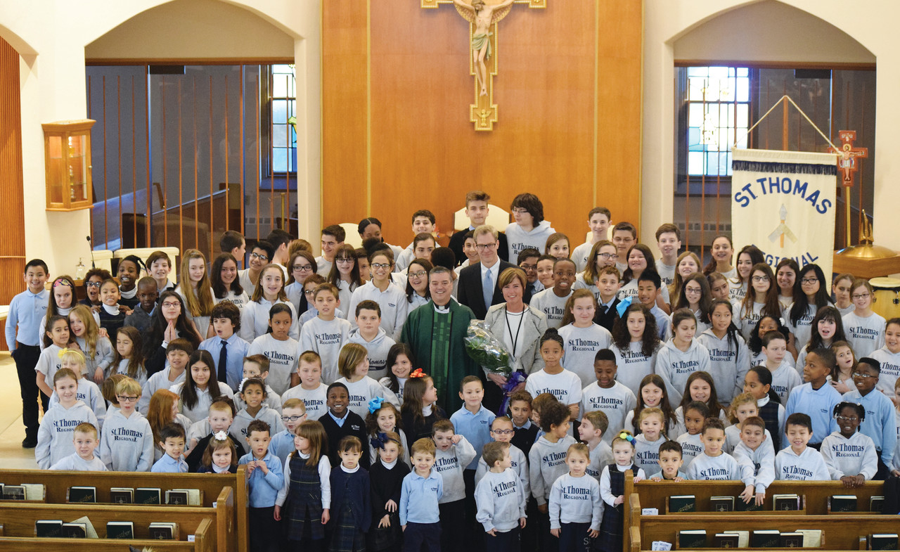 Catholic Schools Superintendent Dan Ferris stands at center with St. Thomas Parish Pastor Father John Soares and St. Thomas Regional School Principal Mary DiMuccio among the school’s student body following a special Catholic Schools Week Mass on Feb. 3. During the Mass the superintendent presented Father Soares with the Catholic Schools Office’s Distinguished Pastor Award and Mrs. DiMuccio with the Distinguished Catholic Elementary School Principal Award.