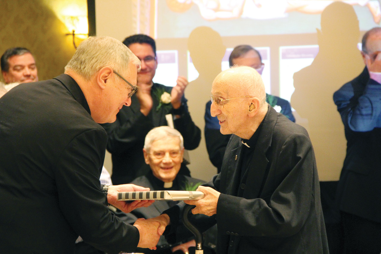Bishop Tobin presents Father Czeslaw L. Kachel with a gift as he celebrates 60 years of priestly service.