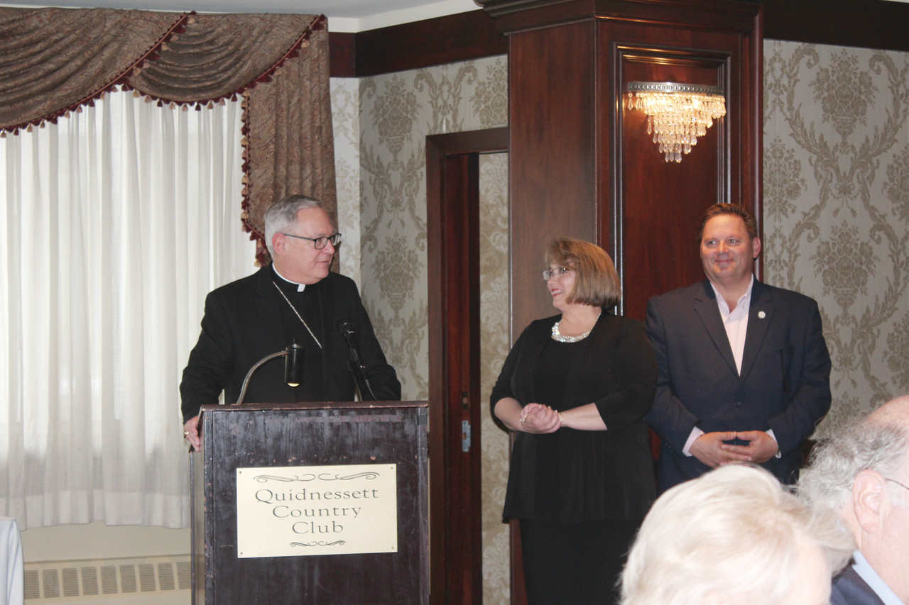 A Faithful Partner in Charity: With Reneé Brissette, executive director of the St. Vincent de Paul Diocesan Council of Providence, and Mark Gordon, president of the Society looking on, Bishop Thomas J. Tobin addresses the gathering at the organization’s Rhode Island Friends’ Fund benefit at which he was honored with the 2017 Ozanam Award for leading Rhode Island’s faithful as a Community Partner. Also honored were James Farrington, of Newport, and Dillia Sylvester, of West Warwick.