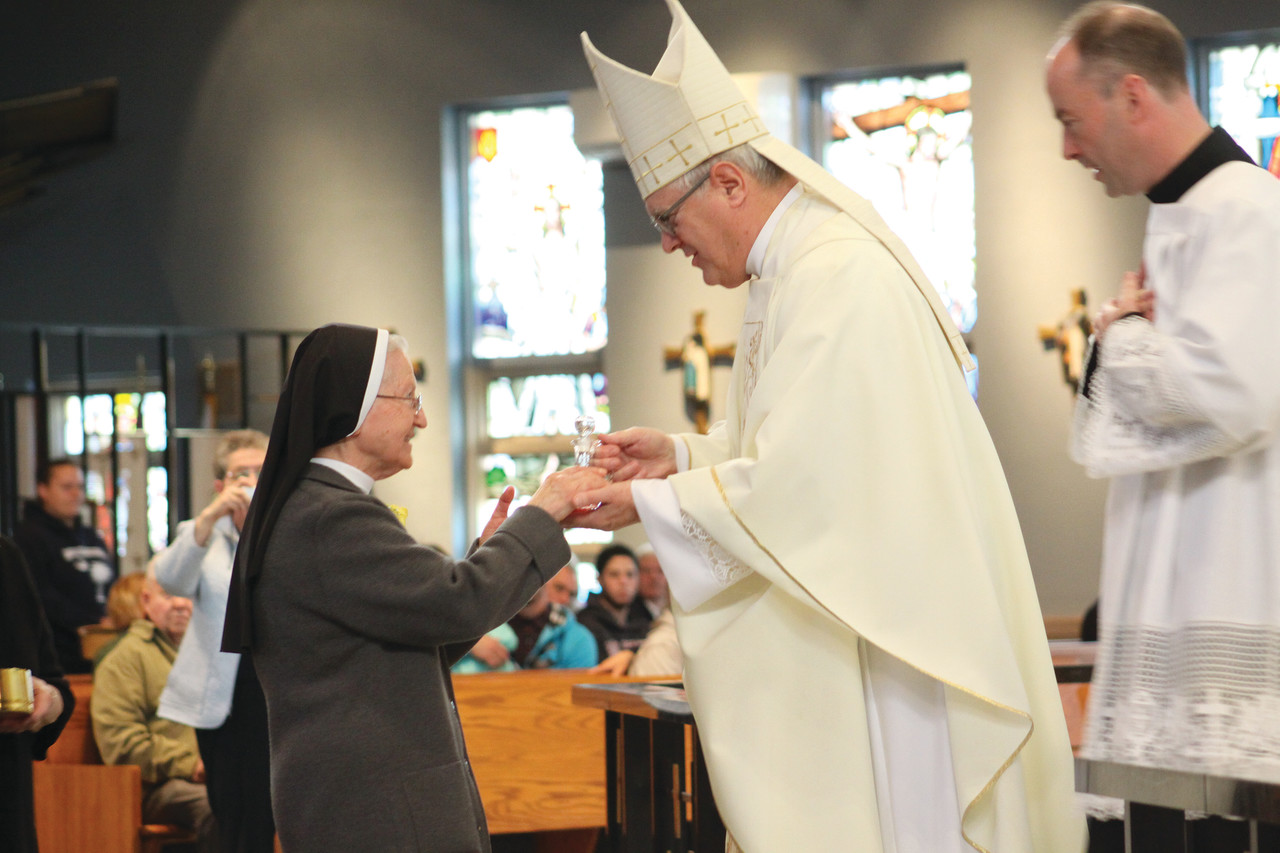 Sister Mary Antoinette, a Daughter of Our Lady of the Garden celebrating 60 years of religious life, offers the wine to Bishop Tobin during Sunday’s Mass honoring religious jubilarians.