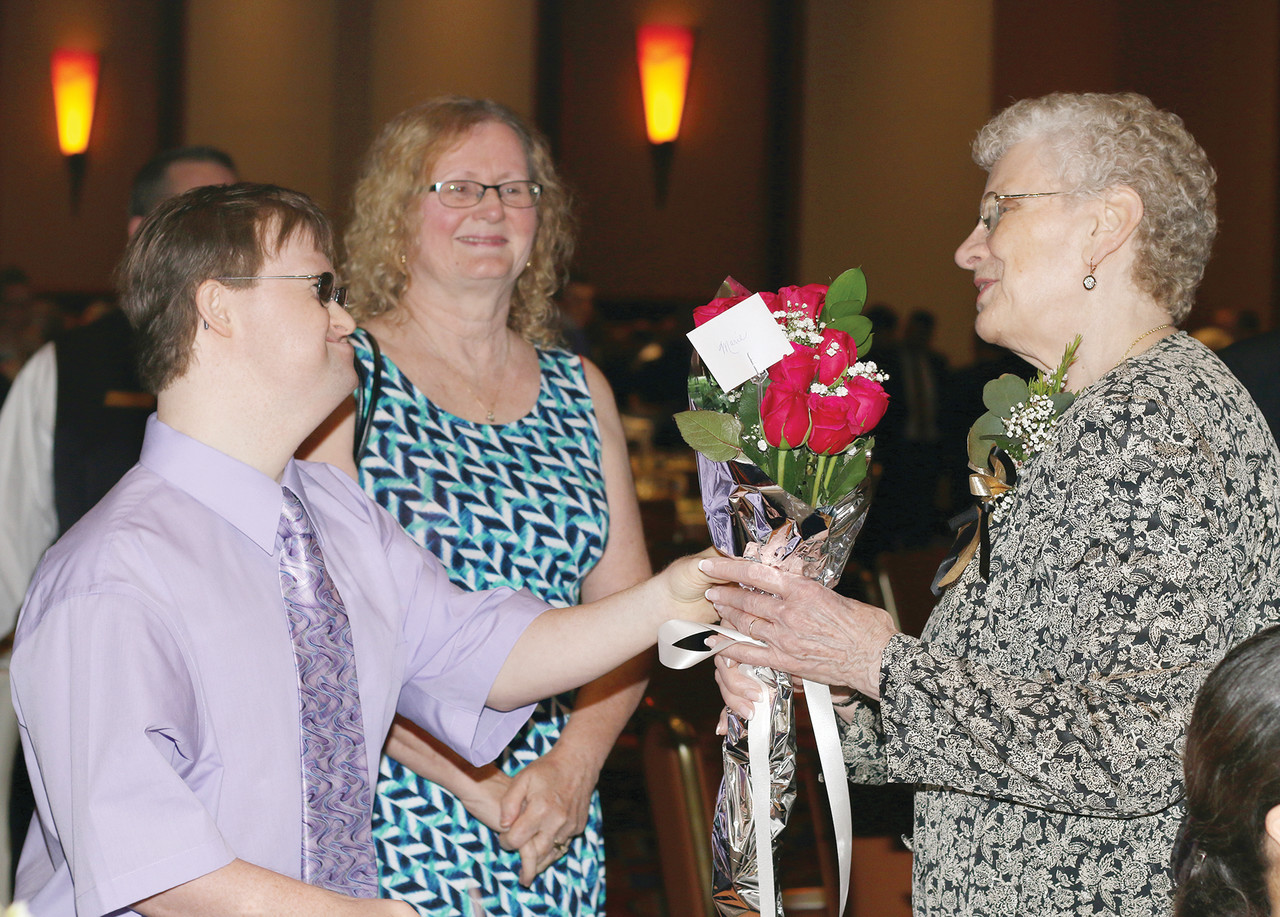 A friend presents flowers to Marie Wilson, winner of a Lumen Gentium Award in Parish Service.