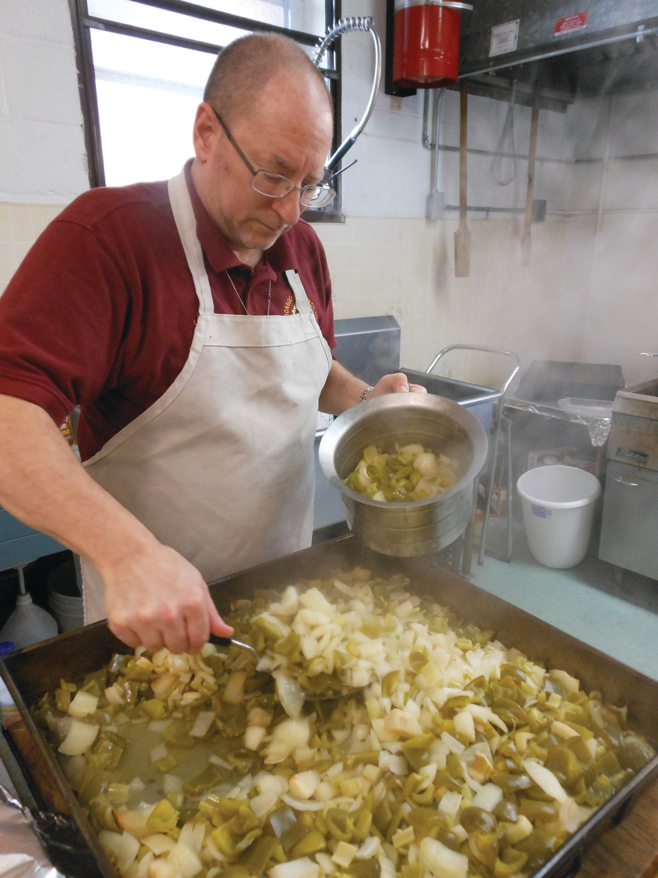 Jack Tracy, a member of the Knights of Columbus Woonsocket Council, prepares the peppers, onions and celery for a batch of dynamites. The Knights of Columbus have held an annual dynamite fundraiser to benefit youth ministry in the Diocese of Providence since 2012.