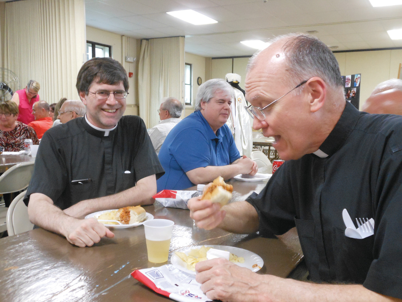 Father Michael Woolley (left), pastor at St. Joseph Church, Woonsocket, and Father Michael Kelley, pastor at St. Agatha and Precious Blood Churches, Woonsocket, chow down on dynamite sandwiches at the annual Teens Are Dynamite fundraiser sponsored by the Knights of Columbus State Council to benefit the Father Marot CYO Center and Rejoice In Hope Youth Center and hosted in St. Agatha Parish hall.