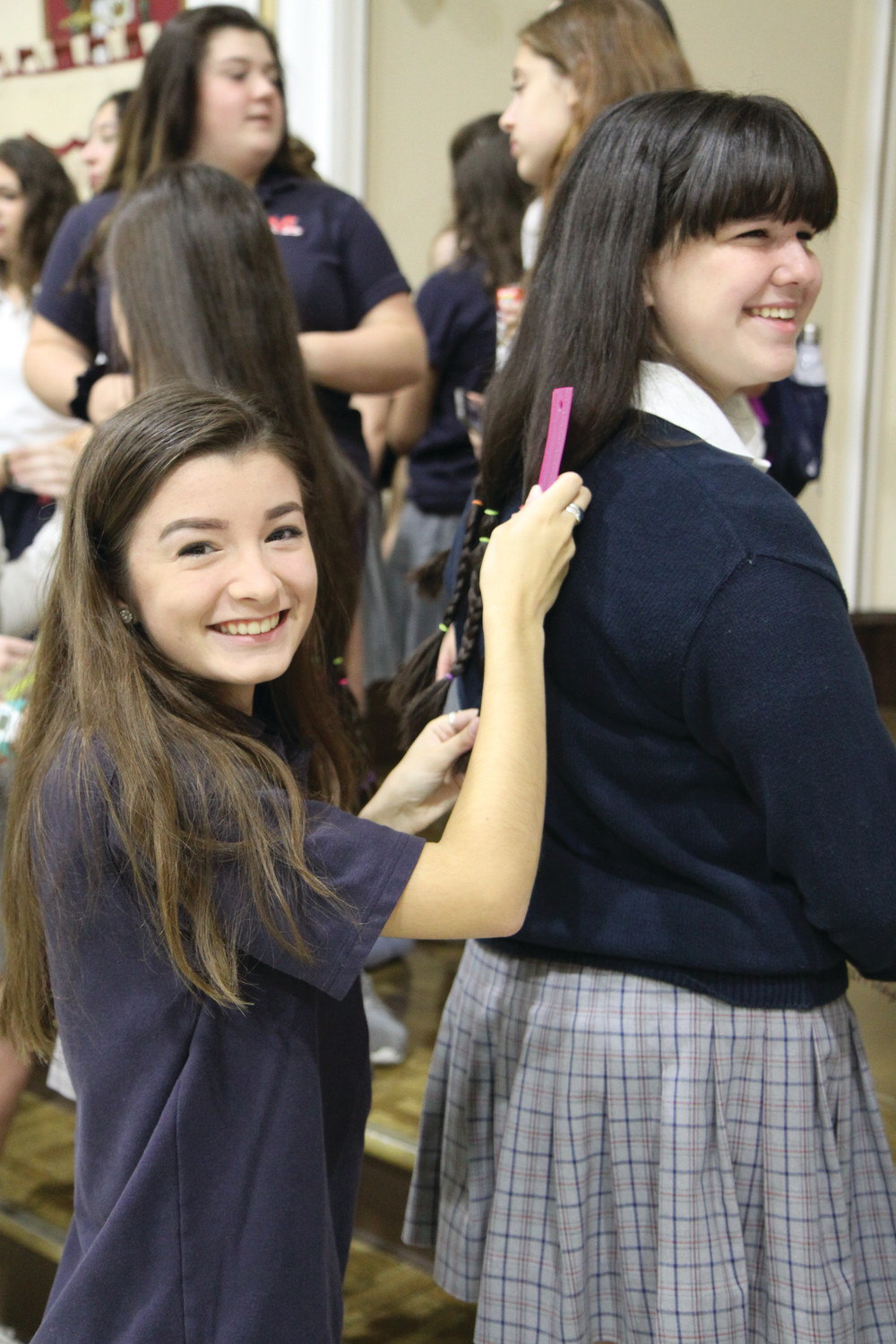 Marissa Kanakry measures fellow student Emma Van Reysen’s hair before it is cut for donation.