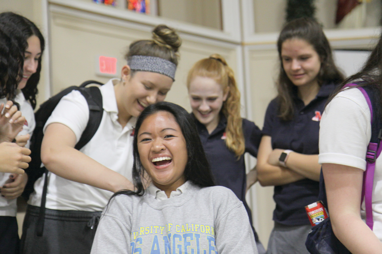 Lena Nguyen reacts as her classmates cut her hair.