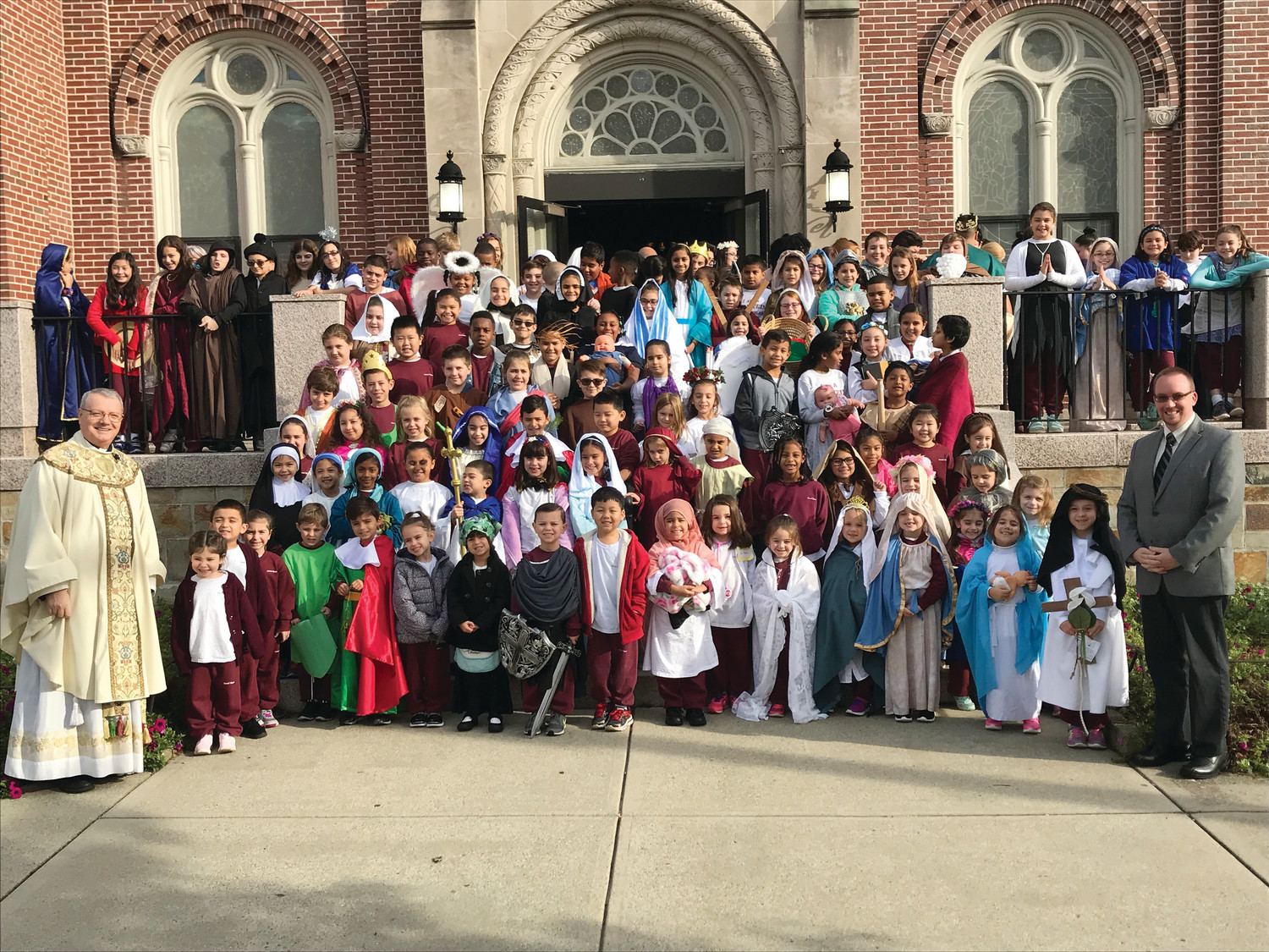 Students at Sacred Heart School join the parish pastor Father Silvio De Nard S.d.C., and Principal James Woodmansee in celebrating the holy day.