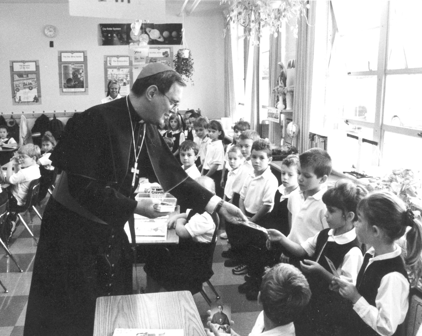 In a photo first featured in May 2005, in the farewell edition of The Catholic Exponent, the official newspaper of the Diocese of Youngstown, Bishop Tobin visits with Catholic school children. Youngstown’s Superintendent of Catholic Schools at the time, Dr. Michael Skube, shared that the most profound way Bishop Tobin witnessed to Catholic education was by visting schools to talk, listen and pray with students.