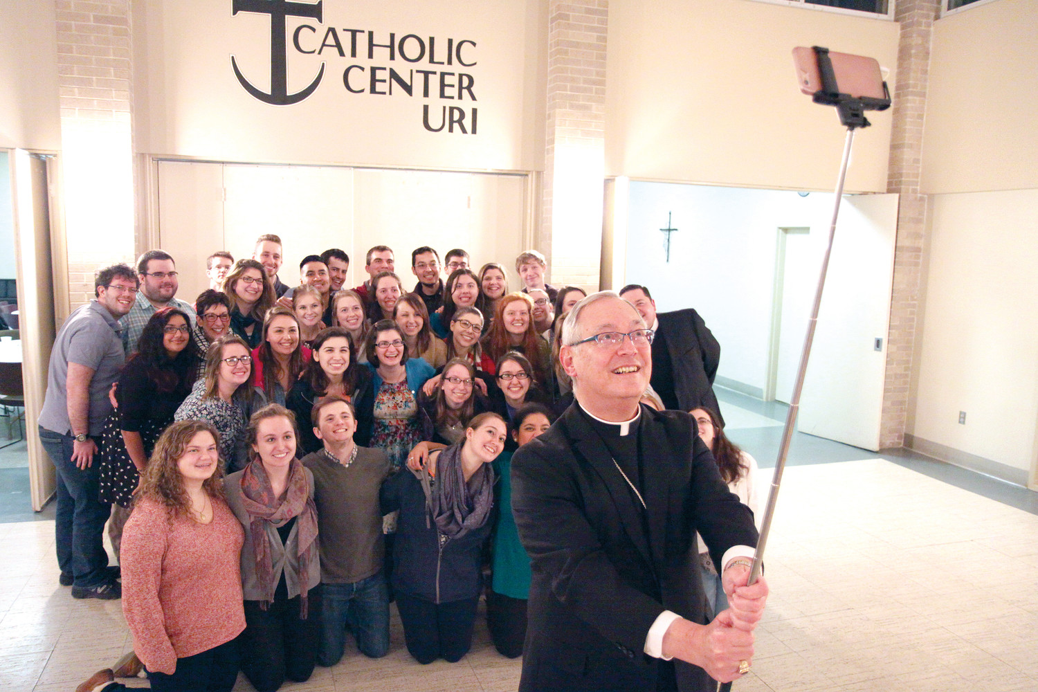 In March 2016, Bishop Tobin takes a selfie with students during a visit to the Catholic Center at the University of Rhode Island.