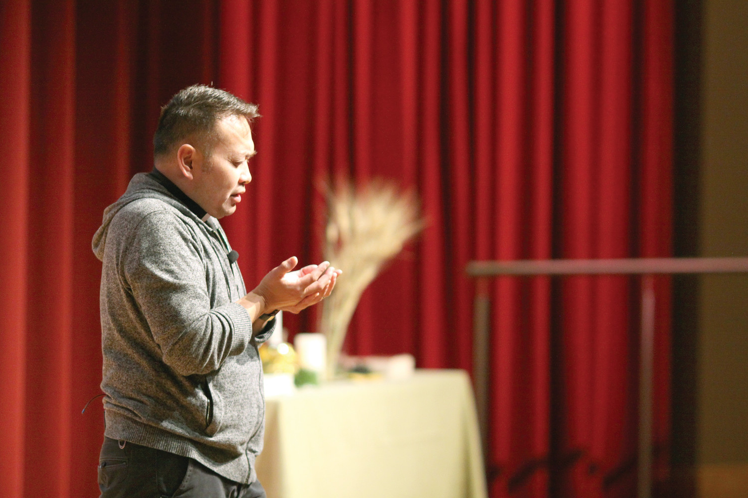 Father Leo Patalinghug, a traveling speaker, chef and priest known for his ministry with Grace Before Meals, leads students in prayer during a presentation at McVinney Auditorium on Friday, December 1.
