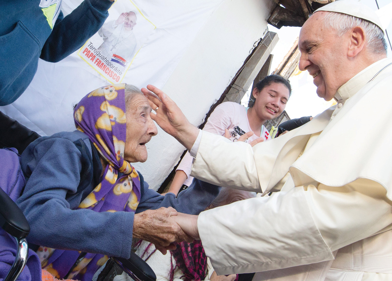 Pope Francis greets an elderly woman as he meets with people of the Banado Norte neighborhood in Asuncion, Paraguay, in this July 12, 2015, file photo. The pope has shown special concern for the aged, the sick and those with disabilities.
