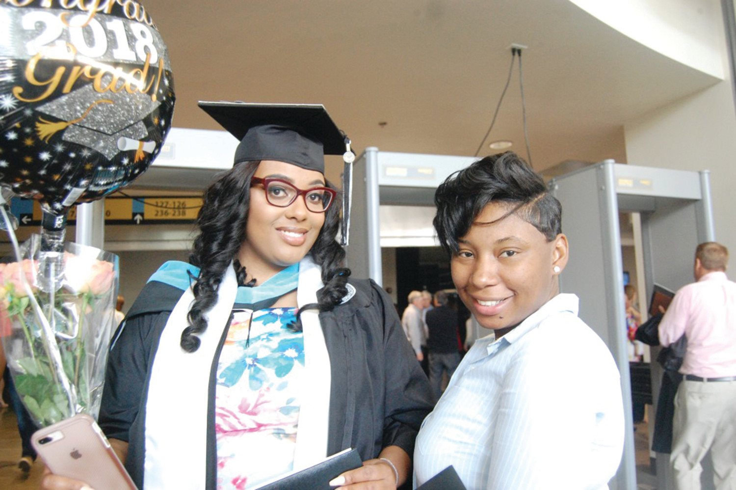 Quameé Andrade, left, who received her Master’s in Education, smiles with her sister Denise Geegbae following her graduation from Providence College.