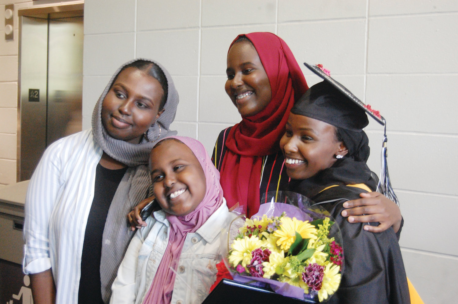 Fartun Abdulle, of Lawrence, Mass., smiles with her sisters, from left to right: Fardowsa, Aisha and Maka following graduation from Providence College.