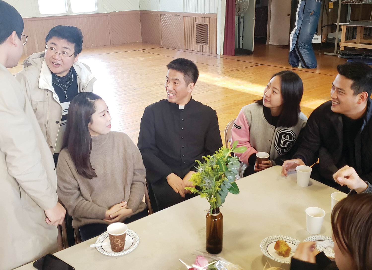 Father Jaekyu Lee, Chaplain to Rhode Island’s Catholic Korean community and assistant pastor at St. Paul Church in Cranston, visits with Korean faithful after Mass.