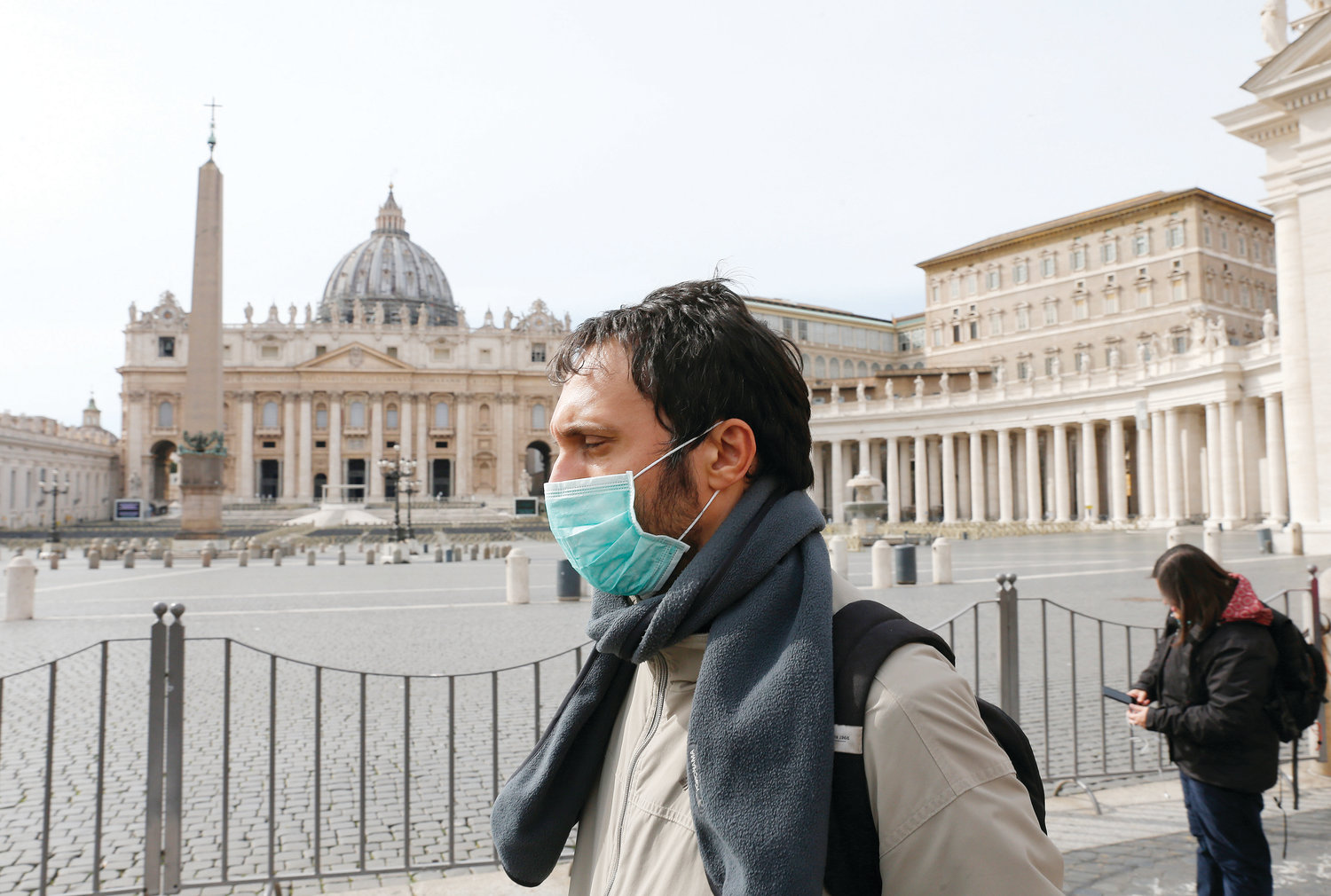 A man wearing a mask for protection from the coronavirus passes an empty St. Peter’s Square at the Vatican March 10, 2020. The Vatican has closed St. Peter’s Square and Basilica to tourists March 10 through April 3 in cooperation with Italian emergency procedures aimed at preventing the spread of the coronavirus.