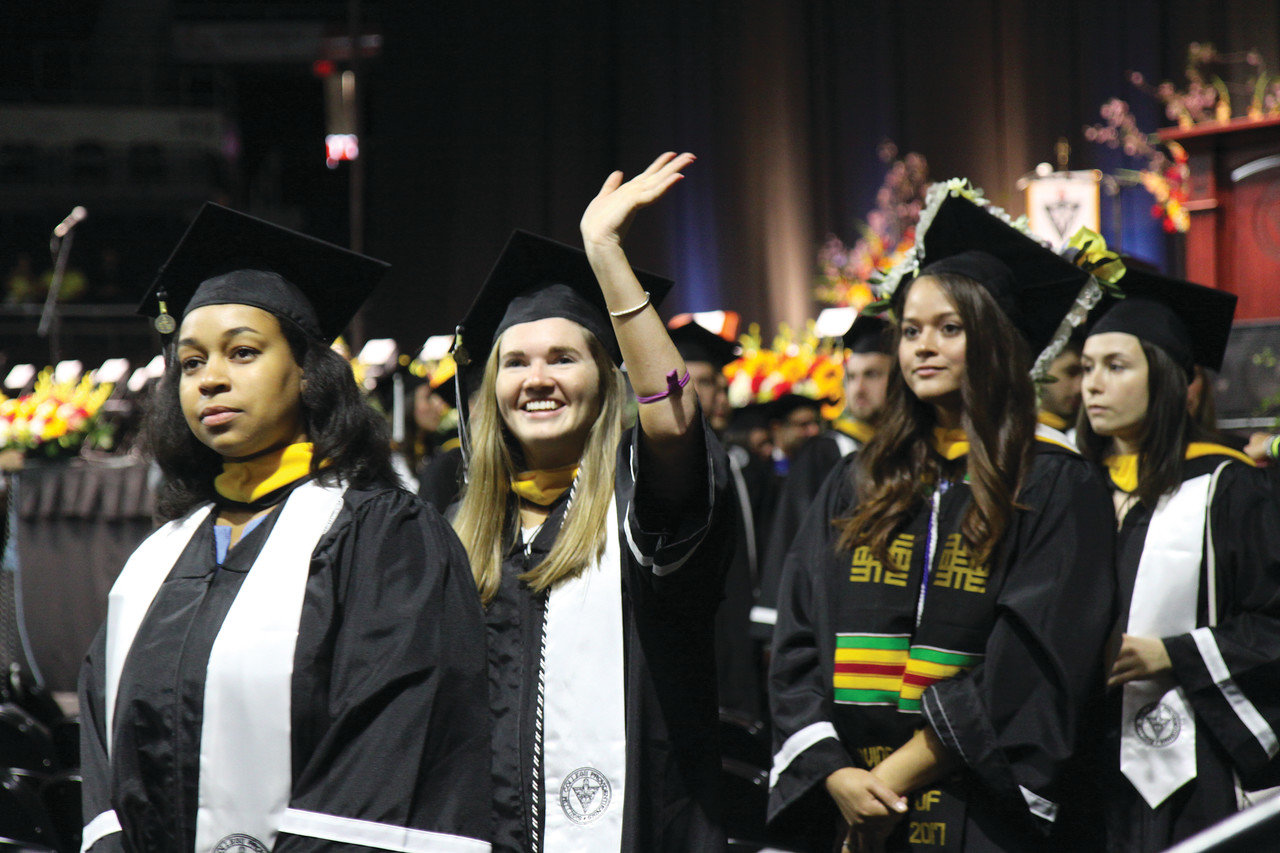 A graduate waves to her family in the crowd during the 2017 annual Providence College Commencement exercises.