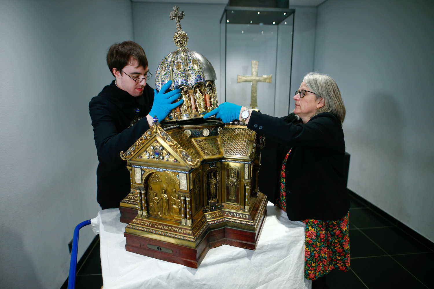 Restorer Luke Jonathan Koeppe and Birgitta Falk, an official of the cathedral in Aachen, Germany, assemble the shrine with the relics of St. Corona March 25, 2020.