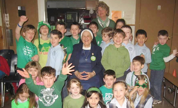 Sister Mary Angelus and Anne Robinson's first grade class gather for a photo on St. Patrick's Day.