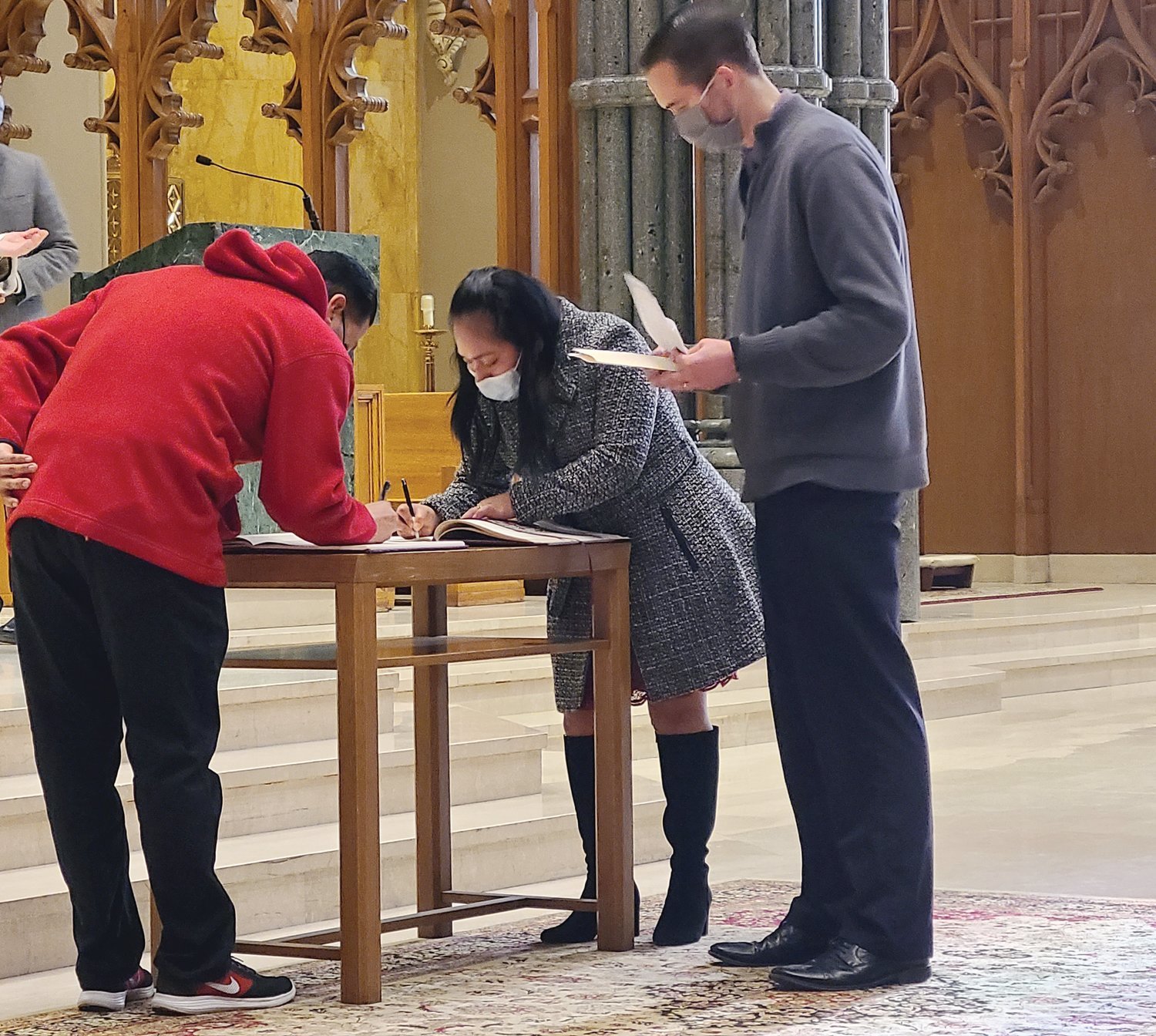 A catechumen signs the Book of the Elect during the Rite of Election, which was held Feb. 21 at the Cathedral of Saints Peter and Paul.