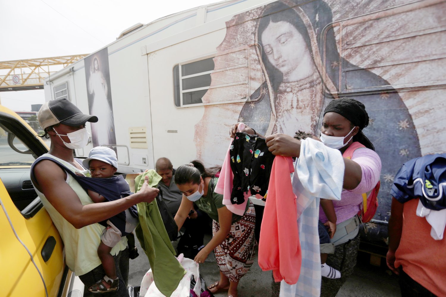 Images of Christ and Our Lady of Guadalupe are pictured as Haitian migrants seeking refuge in the U.S., choose donated clothes outside a shelter in Monterrey, Mexico, Sept. 28, 2021.