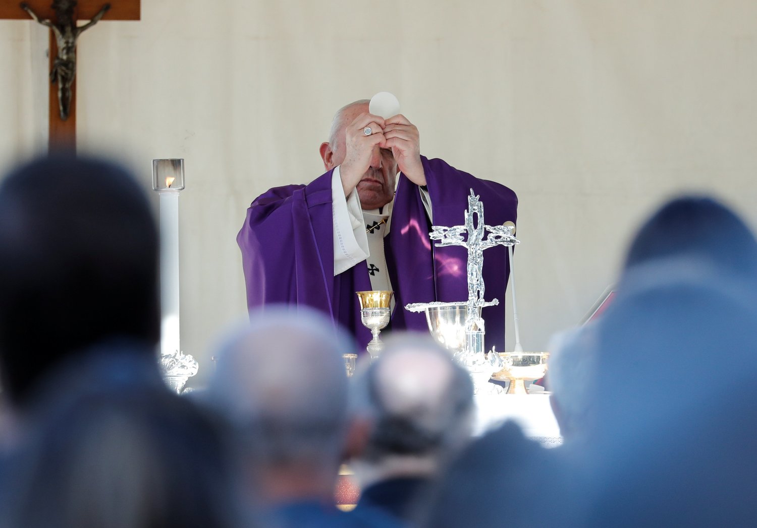 Pope Francis elevates the Eucharist as he celebrates All Souls' Day Mass at the French Military Cemetery in Rome Nov. 2, 2021.