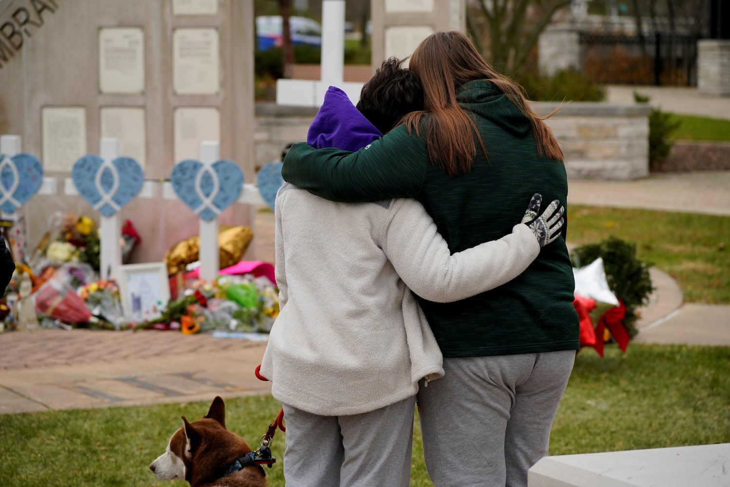 People in Waukesha, Wis., embrace while visiting a memorial Nov. 24, 2021,  the morning after the sixth victim Jackson Sparks, 8, passed away inside Children's Hospital of Wisconsin as a result of injuries sustained when a car plowed through a holiday parade.