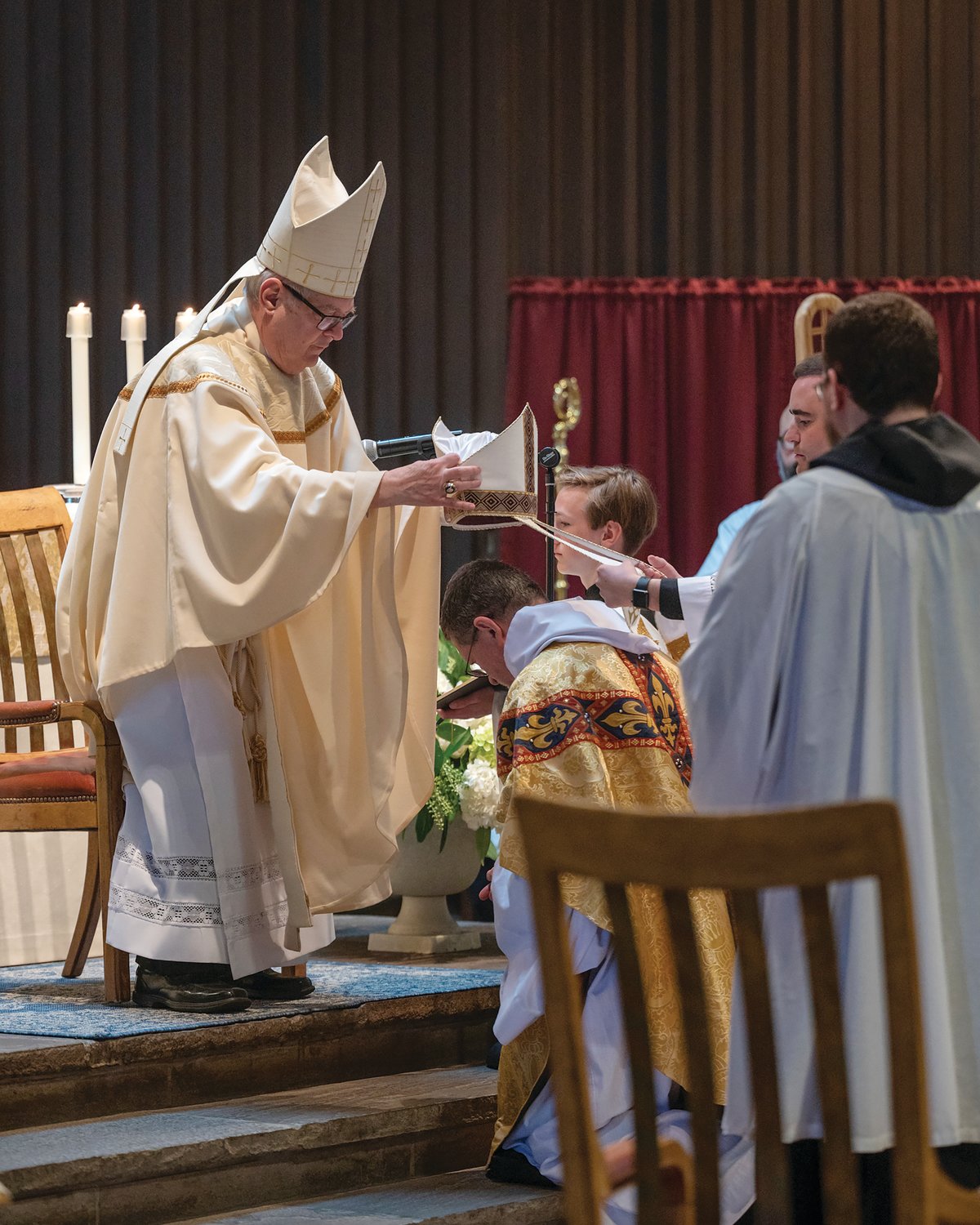 Father Michael Brunner, O.S.B., sits before Bishop Thomas J. Tobin as the bishop delivers the homily during his Abbatial Blessing.