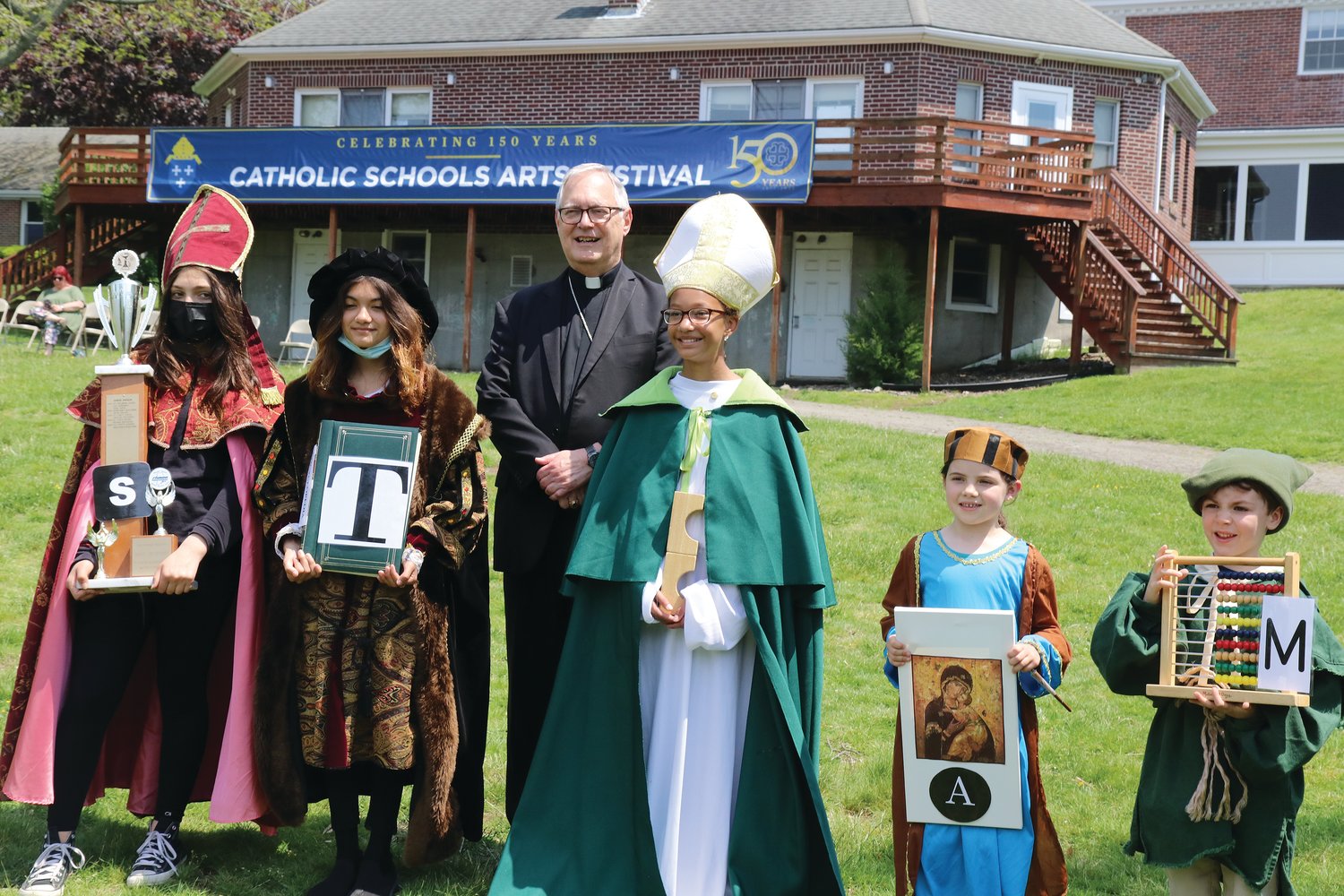 Bishop Thomas J. Tobin gathers with the Saints of S.T.E.A.M., from All Saints Academy: from left, Francesca Vidotto, grade 7; Trinity Maghuyop, grade 7; Ava Wiggins, grade 5; Rosemary McStravick, Kindergarten; Frank Long, Pre-K.