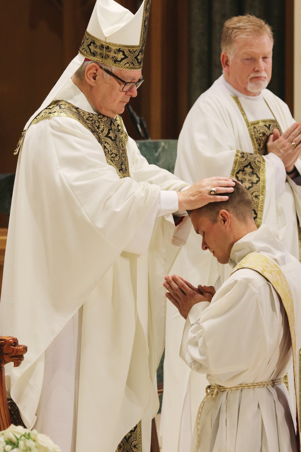 Bishop Thomas J. Tobin lays his hands upon the head of the elect.