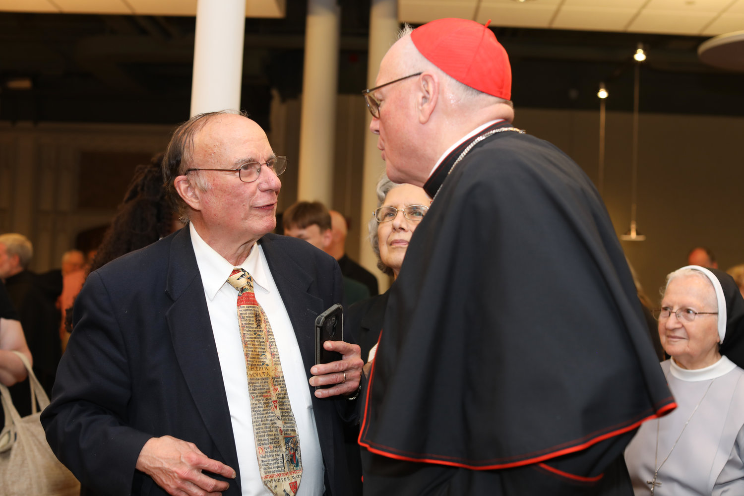 Richard Dujardin, longtime religion reporter for The Providence Journal, accompanied by his wife Rose-Marie, speaks with Cardinal Timothy M. Dolan, Archbishop of New York, during the Cardinal’s special presentation at the Cathedral of Saints Peter and Paul as part of the Diocese of Providence’s 150th anniversary celebration on Sunday, May 15. Dujardin, 77, died in a fall on Aug. 15 in Milwaukee.