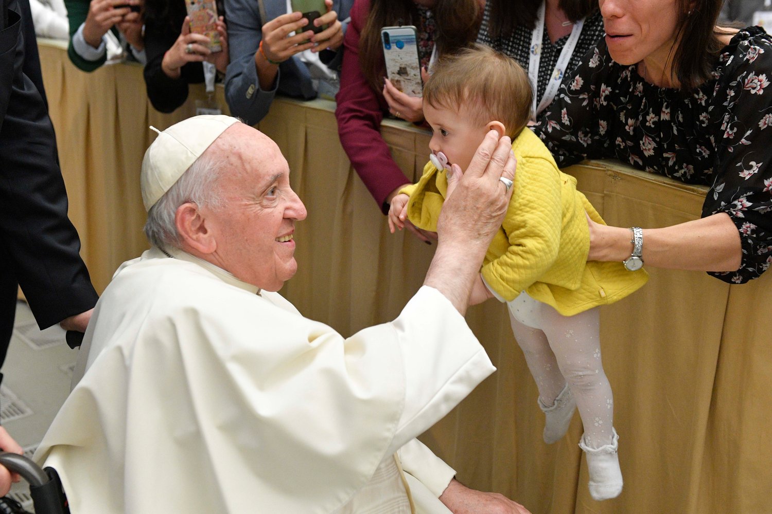 Pope Francis embraces a baby as he leaves an audience Oct. 29, 2022, at the Vatican with members of the young adult section of Italy's Catholic Action.