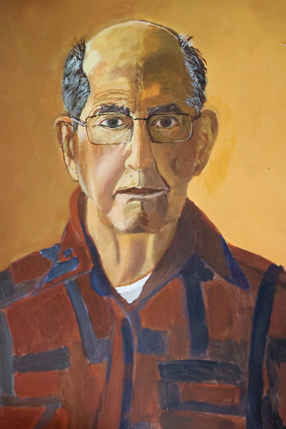 Father Raymond Tetrault left behind a legacy of colorful paintings. Beginning with religious scenes from the Bible, Father Raymond later painted portraits that reflected injustices he perceived in society. Pictured: A self portrait of Father Raymond