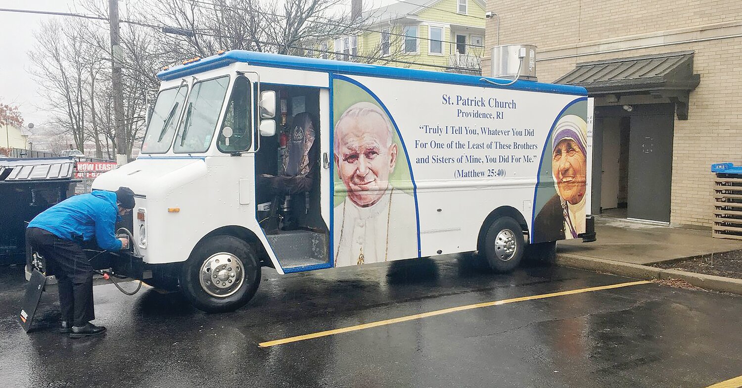 Father James Ruggieri checks the food truck before going out to serve food to the poor.